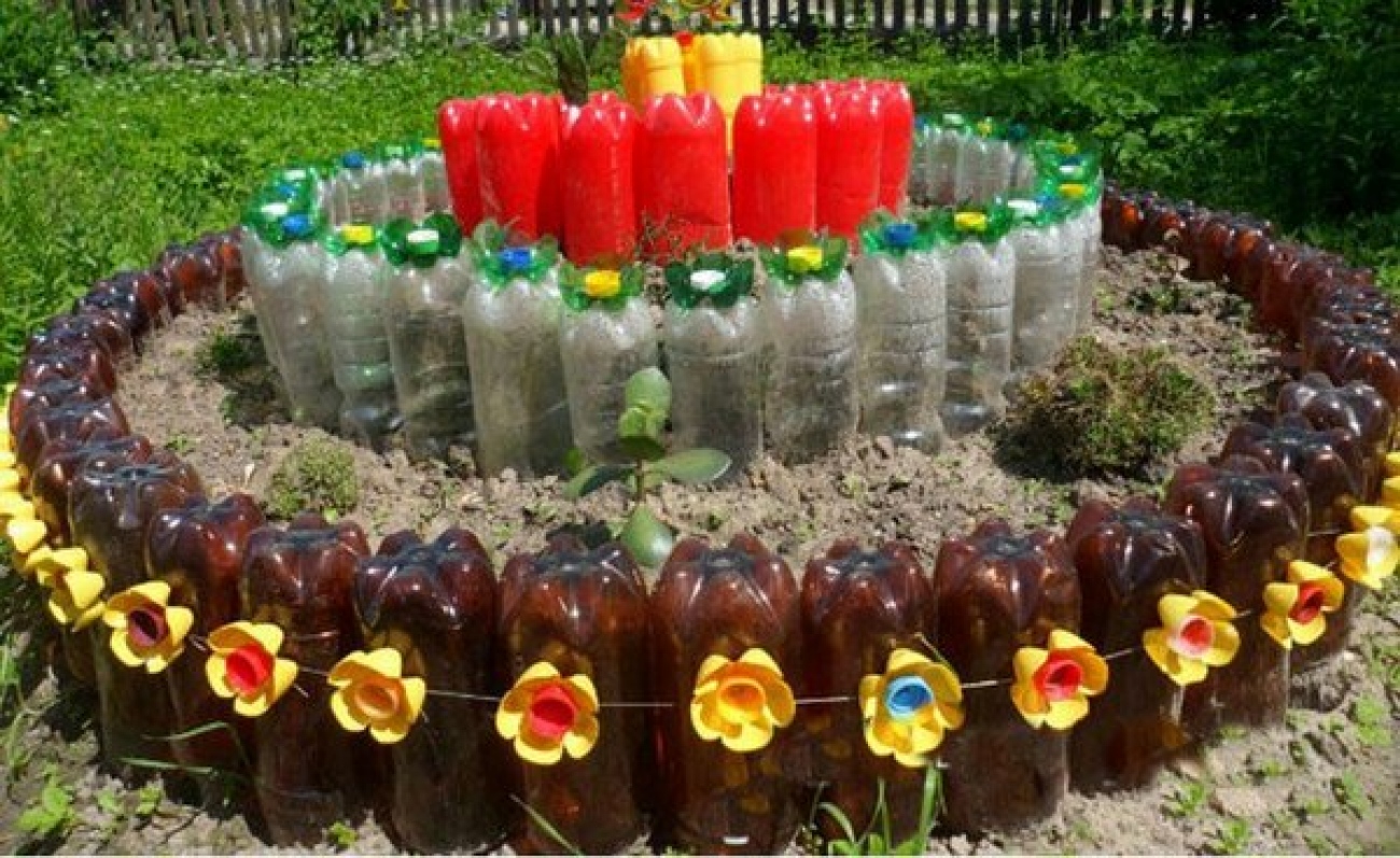 Как сделать из бутылки для сада. Клумбы из пластиковых бутылок. Украшение клумб пластиковыми бутылками. Клумбы из пластмассовых бутылок. Клумбы для цветов из бутылок.